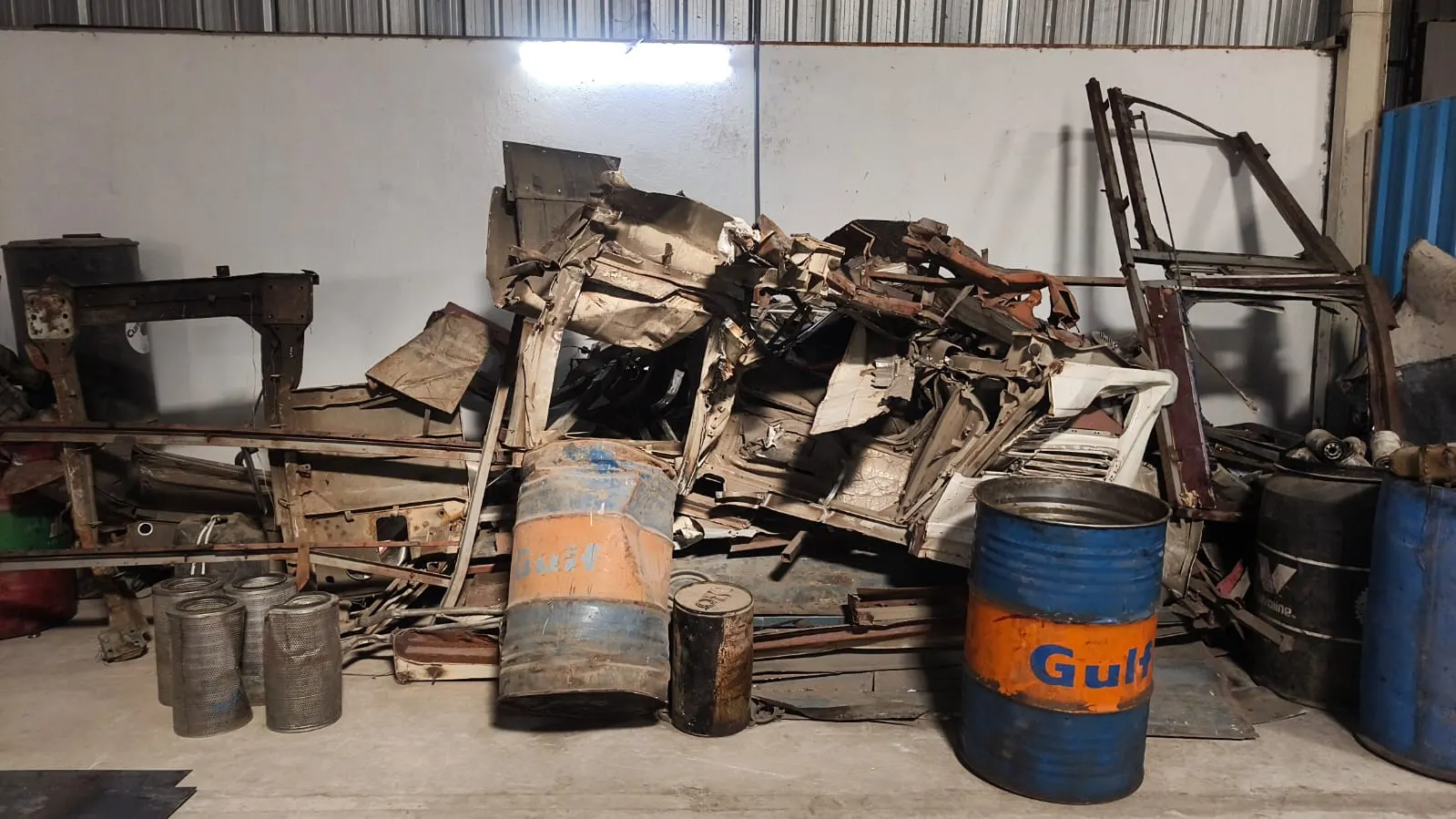 A stripped car body and steel drums at the KGN Enterprises yard in Bakaram, Kavadiguda